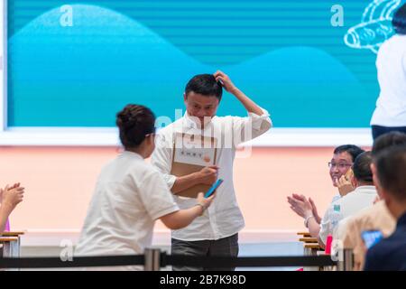 Co-founder and former executive chairman of Alibaba Group Jack Ma, middle, takes pictures with a rural teacher at the 'Back to Class' event of the 201 Stock Photo