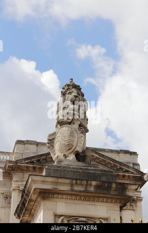 London, UK - May 11, 2019: A stone statue of lion on the gate of Buckingham Palace Stock Photo