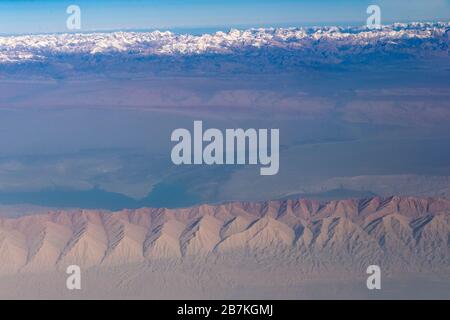 --FILE--An aerial view of the Taklamakan Desert, China's largest and world's 10th largest desert, with mountains whose tops are covered by snow, in Ka Stock Photo