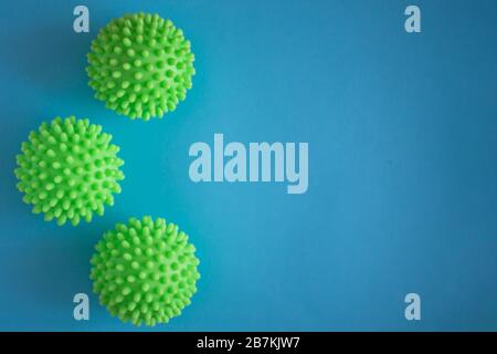 Close up of three green spiky coronavirus models isolated on blue background. Pandemic desease spreading worldwide. Medical treatment of the infected people. Healthcare Stock Photo
