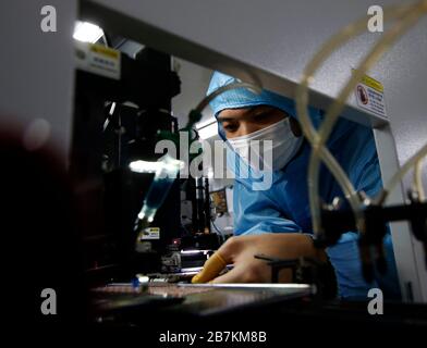 Workers wearing protective garment labor at a high-tech company after long Spring Festival vacation in Sihong county, Suqian city, east China's Jiangs Stock Photo
