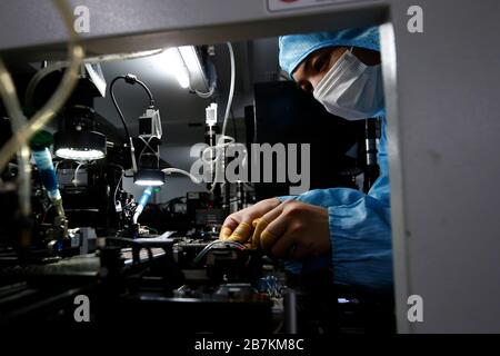 Workers wearing protective garment labor at a high-tech company after long Spring Festival vacation in Sihong county, Suqian city, east China's Jiangs Stock Photo