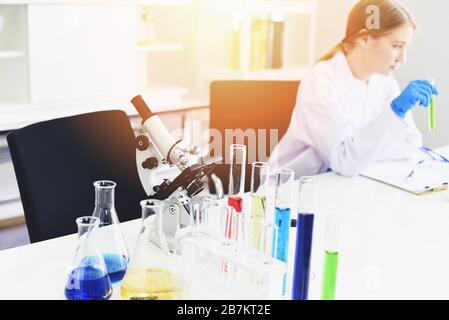 Young female scientist doing some research working conduct experiments and microscope in modern laboratory / Scientists in lab biochemistry genetics f Stock Photo