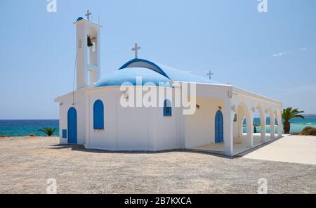 The nice new white and blue church of St. Thekla (Agia Thekla) on the rocky ledge over sea. Ayia Napa. Cyprus Stock Photo