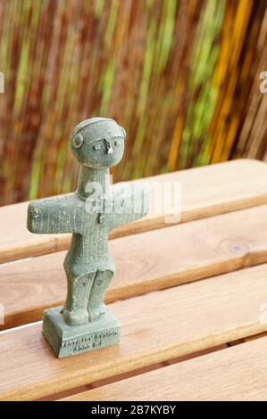 Vertical closeup shot of the Cyprus fertility symbol sculpture on a wooden table Stock Photo