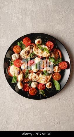 Caprese skewers with tomatoes, mozzarella balls, basil and spices on ...