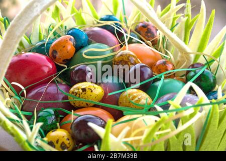 Multicolored painted Easter eggs in hand basket Stock Photo