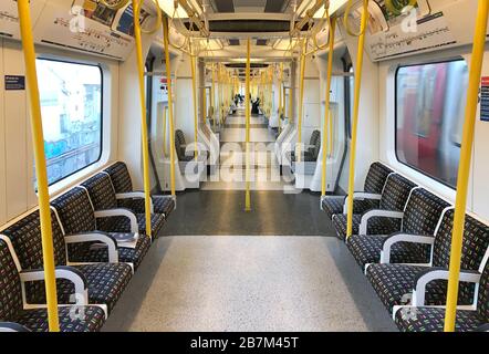 A sparsely-filled carriage on an Underground train in west London the day after Prime Minister Boris Johnson called on people to stay away from pubs, clubs and theatres, work from home if possible and avoid all non-essential contacts and travel in order to reduce the impact of the coronavirus pandemic. Stock Photo