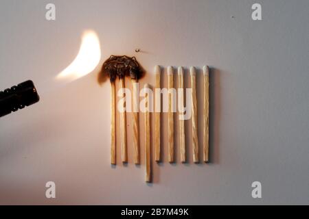 Social distancing concept showing how it can stop spreading of corona virus pandemic. One match with more distance stops burning of others. Stock Photo
