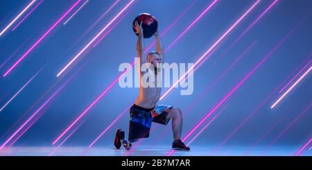 Creative sport and neon lines on blue background, flyer, proposal. Male bodybuilder training in action and motion. Concept of hobby, healthy lifestyle, youth, action, movement, modern style. Inclusive. Stock Photo