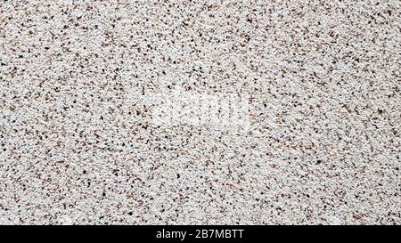 Grainy surface texture of the building facade. Granular plaster. Sandstone texture background details. Top view of the sandy beach. Background with Stock Photo