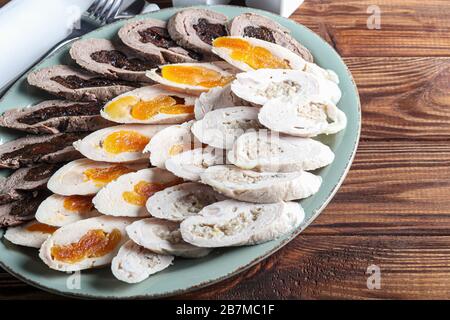 Chicken rolls with dried apricots, prunes and mushrooms. Sliced. On a dark background. Copy space Stock Photo