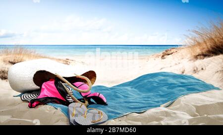 Towel on sandy beach and landscape of the sea in distance. Stock Photo