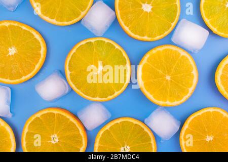 Slices of orange and ice cubes on a blue background.Summer background. Stock Photo