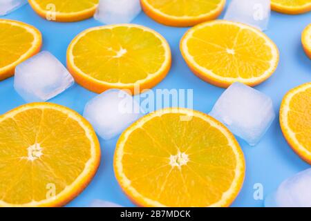 Slices of orange and ice cubes on a blue background.Summer background. Stock Photo