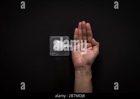 Alcohol gel drop from a bottle on the palm to clean and protect virus with black background for flat lay black concept. Stock Photo