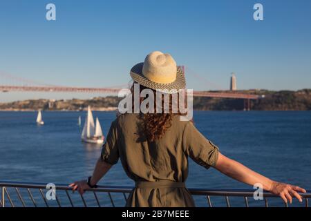 Young woman looking at bridge Ponte 25 de Abril Lisbon Stock Photo