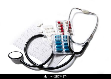 Stethoscope pills and cardiogram on a white background. Stock Photo