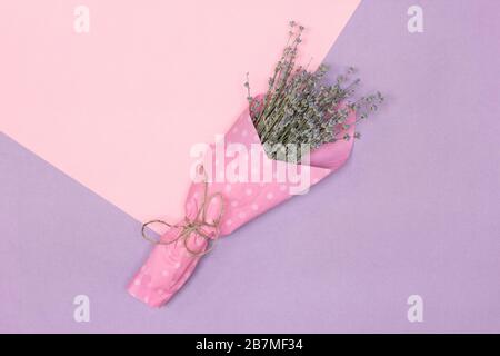 Lavender flower bouquet on pink and lilac background. Minimal floral summer concept in pastel colors Stock Photo