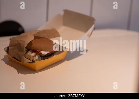 Hamburger in a take away container on table against white background Stock Photo