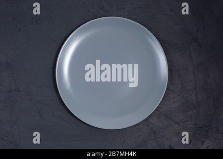 Empty ceramic gray plate on black table Stock Photo
