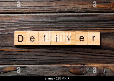 deliver word written on wood block. deliver text on table, concept. Stock Photo