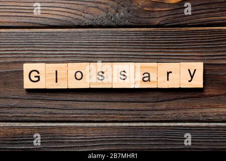 Glossary word written on wood block. Glossary text on wooden table for your desing, Top view concept. Stock Photo