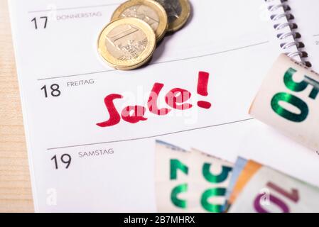 Date for sale in the calendar on which are coins and bank notes. Stock Photo