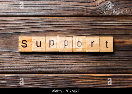 Support word written on wood block. Support text on wooden table for your desing, concept. Stock Photo