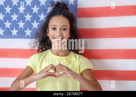 Teenager girl standing on the background of the American flag. Stock Photo