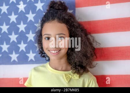 Long haired dark-skinned girl in a yellow tshirt. Stock Photo