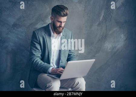 Young confident bearded man using laptop and having online meeting with business investors Stock Photo