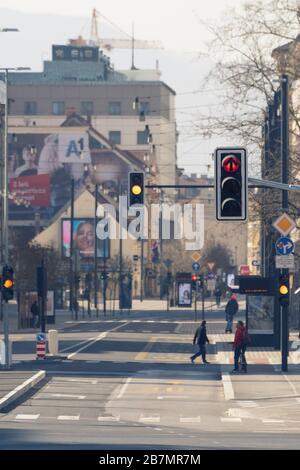Ljubljana, Slovenia - March 17, 2020: Red and yellow traffic lights in downtown Ljubljana, Slovenia on nearly empty streets with few people during the Stock Photo