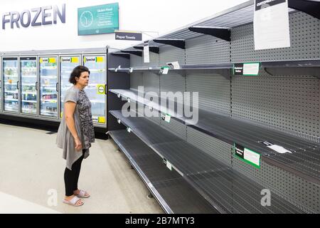 Woolworths Supermarket in Double Bay, Sydney showing empty shelves. A customer looks fed up trying to buy paper towels and the shelf is empty. Stock Photo