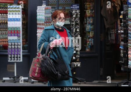 A woman wearing a protective face mask walks along Edinburgh's Royal Mile  during the coronavirus outbreak with a Louis Vuitton bag Stock Photo - Alamy