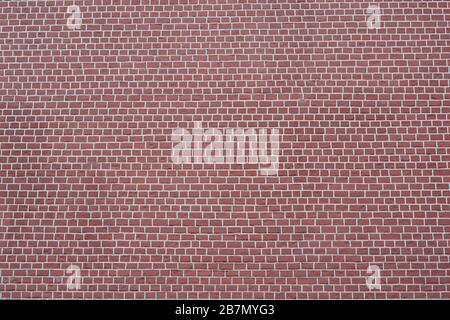 The brick wall is red -brown with white joints. Textured background. Stock Photo