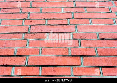 Red brick wall with large grey mortar joints. Bottom view. Background. Stock Photo