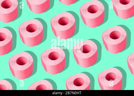 Toilet paper on a colored background. A repeating roll of pink paper. Contemporary art, minimalism. Stock Photo