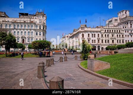 Lima, Peru - April 18, 2018: Tourists walking and talking in Plaza San Martin with gardens and buildings in background. Stock Photo