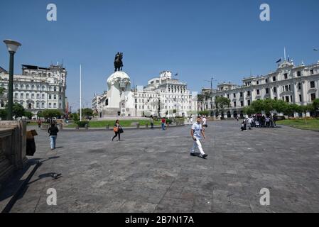 Lima, Peru - April 18, 2018: Tourists walking and talking in Plaza San Martin with statue of General San Martin and buildings in background. Stock Photo