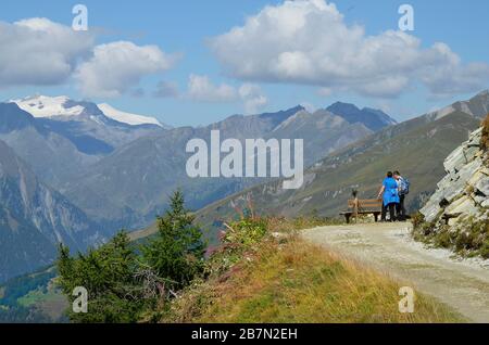 Matrei, Austria - September 05, 2018: Unidentified hikers on path on Goldried moutain with panorama of Austrian Alps Stock Photo