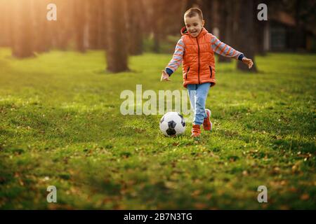 Boy shooting at goal.Little boy kicking football on the sports field Stock Photo