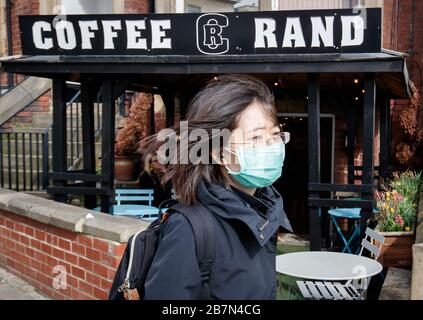 A Woman Wearing A Face Mask Walks Past A Cafe In Leeds West Yorkshire The Day After Prime Minister Boris Johnson Called On People To Stay Away From Pubs Clubs And Theatres Work From Home If Possible And Avoid All Non Essential Contacts And Travel In