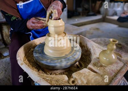 Closeup of Local woman demonstrates on making traditional clay jar called Labu Sayong or Essence Jar of Sayong inside workshop in Kuala Kangsar, Perak Stock Photo