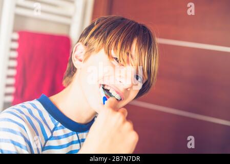 Young boy brushing his teeth on waking up in the bathroom New day of ordinary life Stock Photo