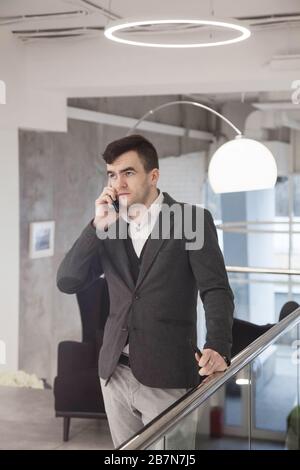 young businessman in a loose suit works in a light office Stock Photo