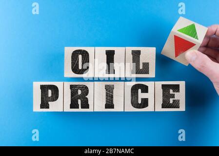 falling or rising oil prices concept with hand turning wood cube with red and green arrow symbol Stock Photo