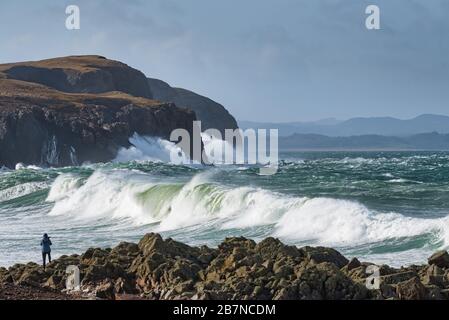 Photographer taking picture of large waves coming in from the Atlantic ocean on the rocky shore at Dunaff County Donegal Ireland Stock Photo