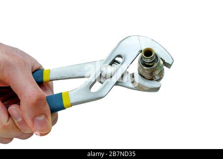 Plumbing wrench in the hand. Tool for plumbing. The old coupling is clamped in a wrench. Isolated photo. Stock Photo