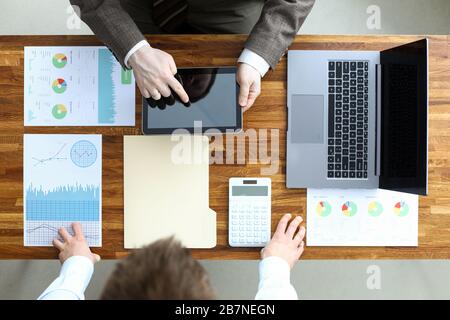 Men standing over table analyze data and make plan Stock Photo